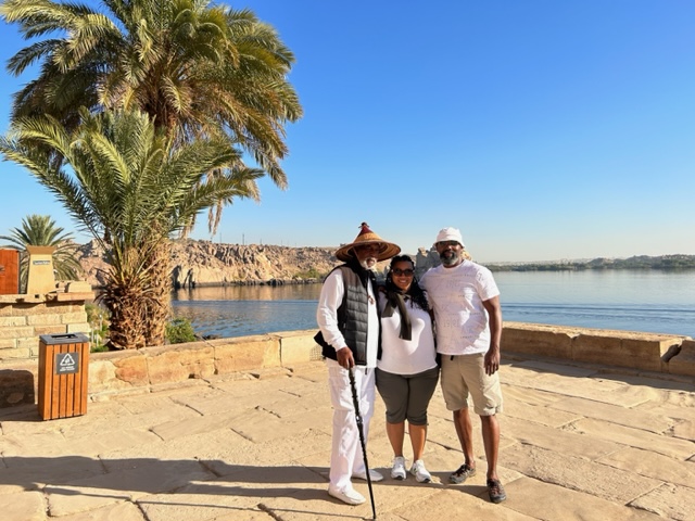 Three people standing in front of a body of water.