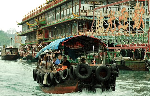 A group of people on a boat in hong kong.