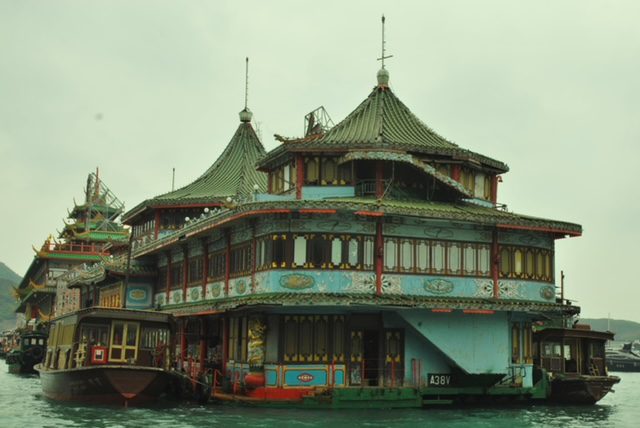 A boat with a house on it floating in the water.